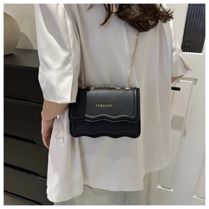Black pebbled leather crossbody chain bag with scalloped edge and golden lettering