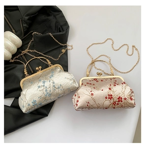 Detailed embroidery on vintage silk handbags with floral patterns and pearl handles