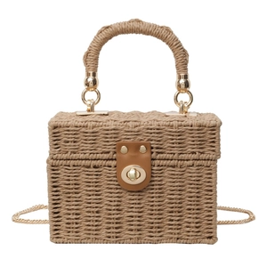 Square straw woven handbag with brown leather strap and gold clasp on white background