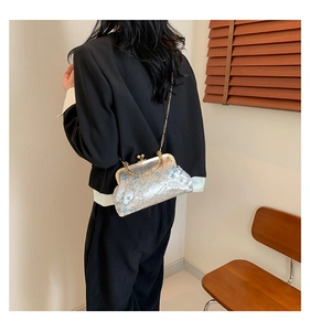 Détail du sac brodé en soie vintage avec chaîne dorée et fermoir à cadre métallique