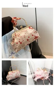 Detail view of red plum embroidery on cream brocade vintage kiss-lock handbag with gold chain