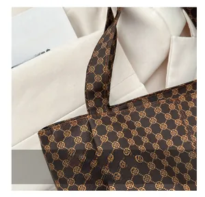Détail du sac cabas rétro avec monogramme montrant des coutures précises et motifs dorés