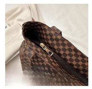 Gros plan détaillé sur la fermeture éclair dorée lisse du sac fourre-tout vintage marron