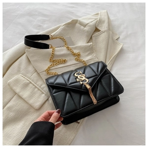 Detail of black quilted leather shoulder bag featuring gold SS logo and chain fringe