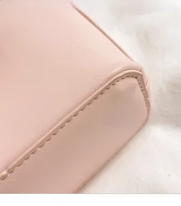 Detail of precise stitching and premium leather texture on a pink bucket bag
