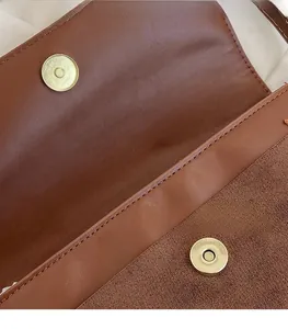 Detail of vintage brown leather handbag featuring a secure gold magnetic snap closure