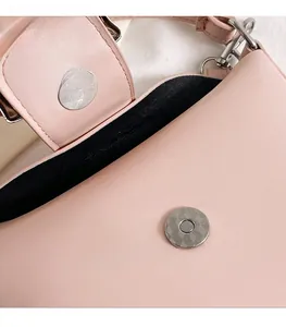 Detailed macro view of the silver magnetic snap closure on a pink pebbled leather bucket bag