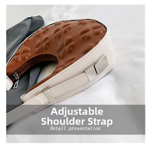 Detail of adjustable leather strap and clover embossed pattern on the shoulder bag