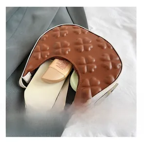 Top view of brown crescent shoulder bag interior showing capacity for phone and cosmetics