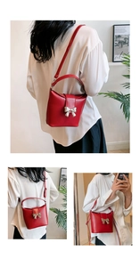 Detail view of red bucket bag with silver bow accent and versatile carry straps