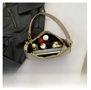 Interior view of beige leather baguette bag showing storage capacity for phone and makeup