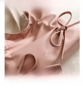 Dettaglio della borsa tote rosa in finta pelle con fiocco e stampa del logo