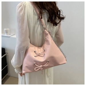 Detail of pink PU leather tote with metal eyelets and decorative drawstring bow detail