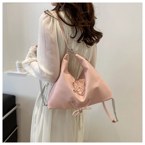 Close-up of pink PU tote bag with cross-lacing detail and silver chain strap for women