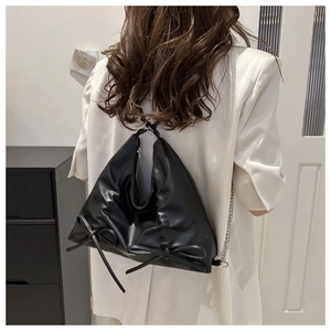 Détail du sac bandoulière noir plissé avec nce avec nœud en cuir et bandoulière chaîne en métal
