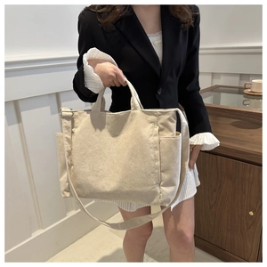 Détail du sac cabas en velours côtelé crème avec texture côtelée et poches latérales