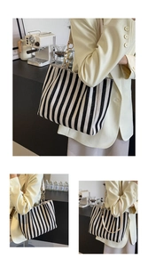 Detail of black and white striped canvas tote bag with metal chain and leather strap