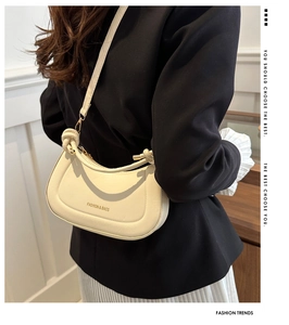 Detail of cream-colored knotted handbag with FASHION & BAGS print and matte finish