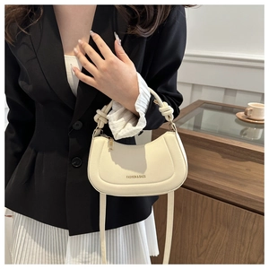 Close-up of off-white crescent bag with knot handle and Fashion & Bags text detail
