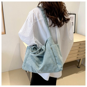 Détail du grand sac cabas en velours côtelé montrant la texture douce et poche latérale