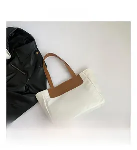 Detail of minimalist tote bag featuring FASHION gold lettering and PU leather stitching