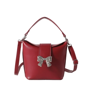Elegant red leather bucket bag with silver bow accent and adjustable shoulder strap