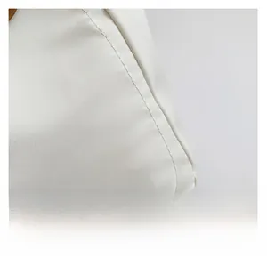 Close-up of durable white nylon fabric and precise stitching detail on tote bag