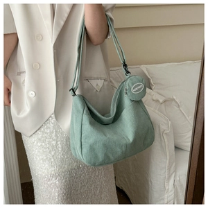 Detail of mint green corduroy crossbody bag with vertical texture and round coin purse