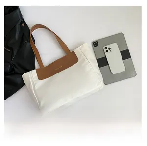 Macro view of large contrast color tote bag with FASHION logo and brown leather straps
