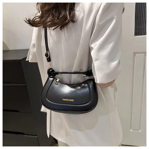 Detail view of black half-moon saddle bag with golden FASHION & BAGS lettering