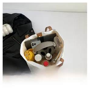 Detail view of large canvas tote bag showing interior capacity with laptop and daily items
