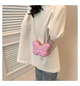 Détail de la pochette papillon rose ornée de strass avec une chaîne dorée