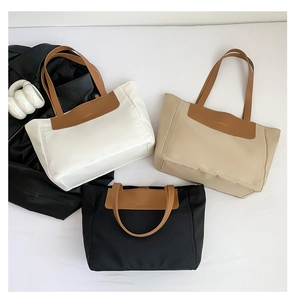 Trio of contrast nylon tote bags in white, beige, and black with brown leather trim