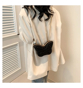 Détail du sac papillon avec cristaux noirs scintillants et fermoir à perle élégant