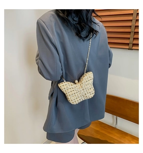 Détail d'un sac papillon doré étincelant orné de strass avec une bandoulière chaîne
