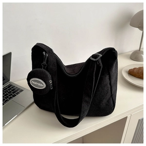 Détail du sac cabas noir en velours côtelé avec une finition texturée et un porte-monnaie