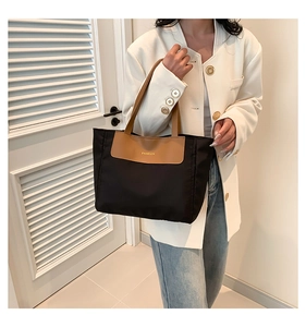 Detailed view of tote bag with brown leather patch and FASHION text in a commute setting