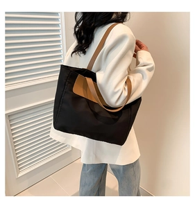 Large black and brown PU tote bag shown on model for daily commuting style