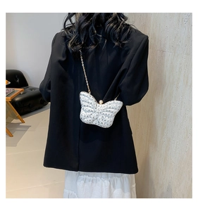 Détail du sac de soirée papillon avec paillettes blanches et bandoulière chaîne dorée