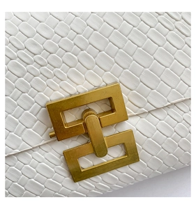 Dettaglio della borsa in pelle intrecciata con grande chiusura geometrica in metallo oro