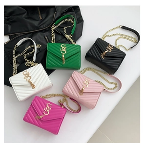Detail of five colorful V-quilted crossbody bags with gold SS logo and tassel charm