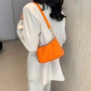 Orange shoulder bag with embossed butterfly pattern and golden hardware details