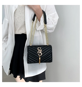 Détail du sac à chaîne noir à surpiqûres en V avec logo SS doré et pompon long