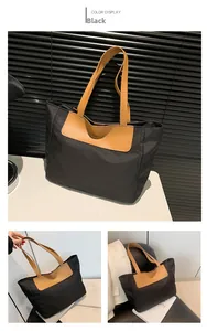Detail view of large black tote bag featuring khaki PU leather handles and fashion logo