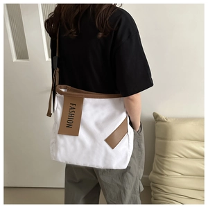 Vista dettagliata della borsa tote in tela con profilo laterale e tracolla marrone su modella