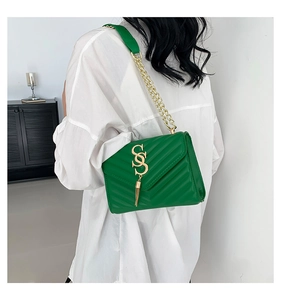 Detail of green crossbody bag with V-quilted texture and gold SS logo tassel charm