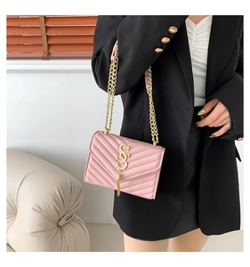 Pink quilted chain crossbody bag with gold-tone fringe detail on a female model