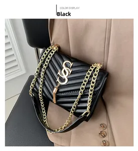 Detail of black quilted crossbody bag featuring gold S-logo buckle and tassel charm