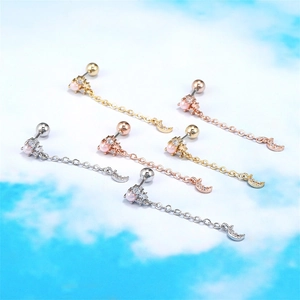 Star and moon barbell earrings set with chains and crystals on a sky background
