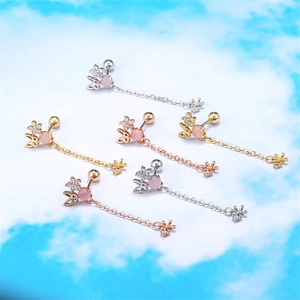 Detail of butterfly earrings with pink stones and dangling chains in gold and silver